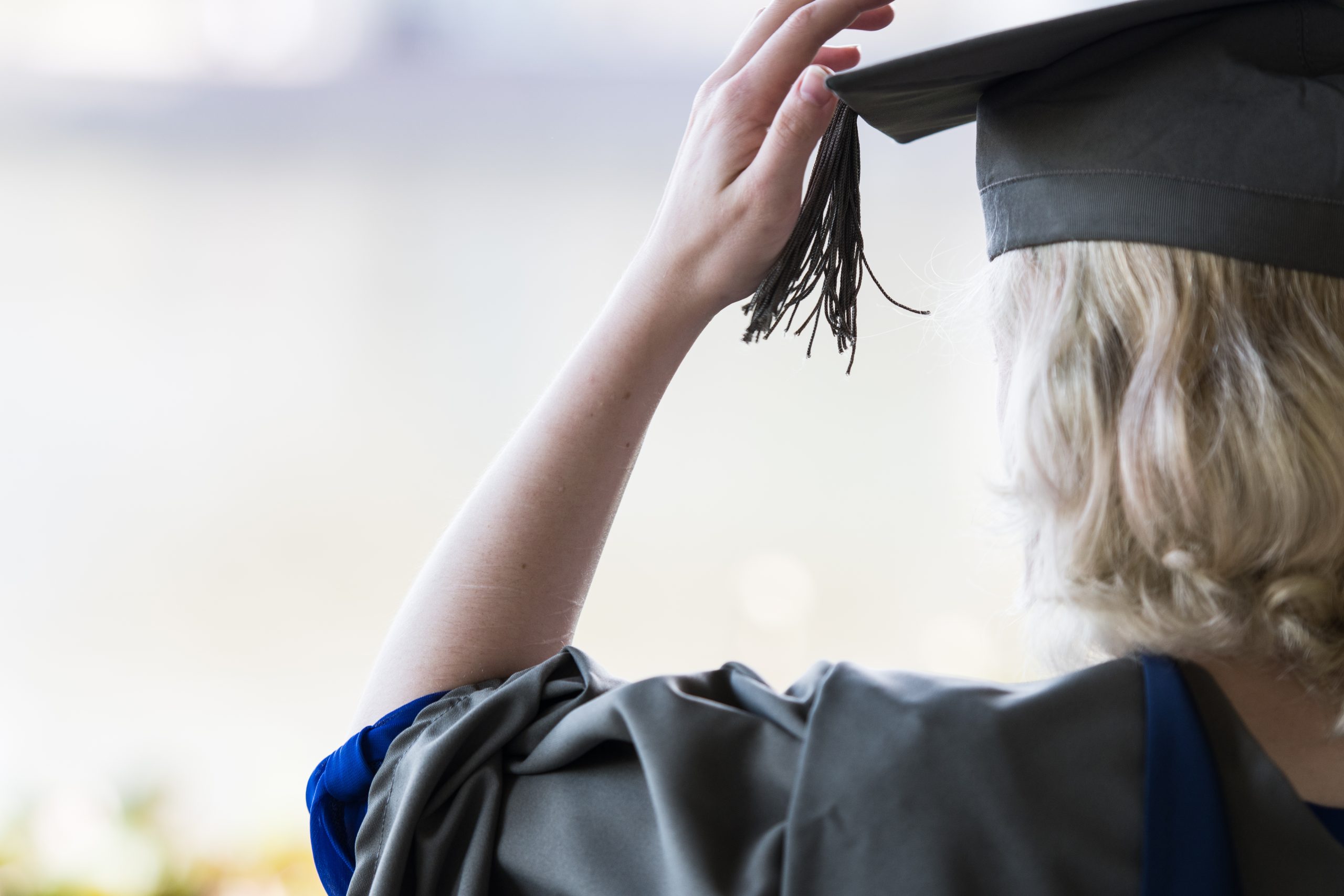 photograph of the back of a student dressed in a graduation cap and gown